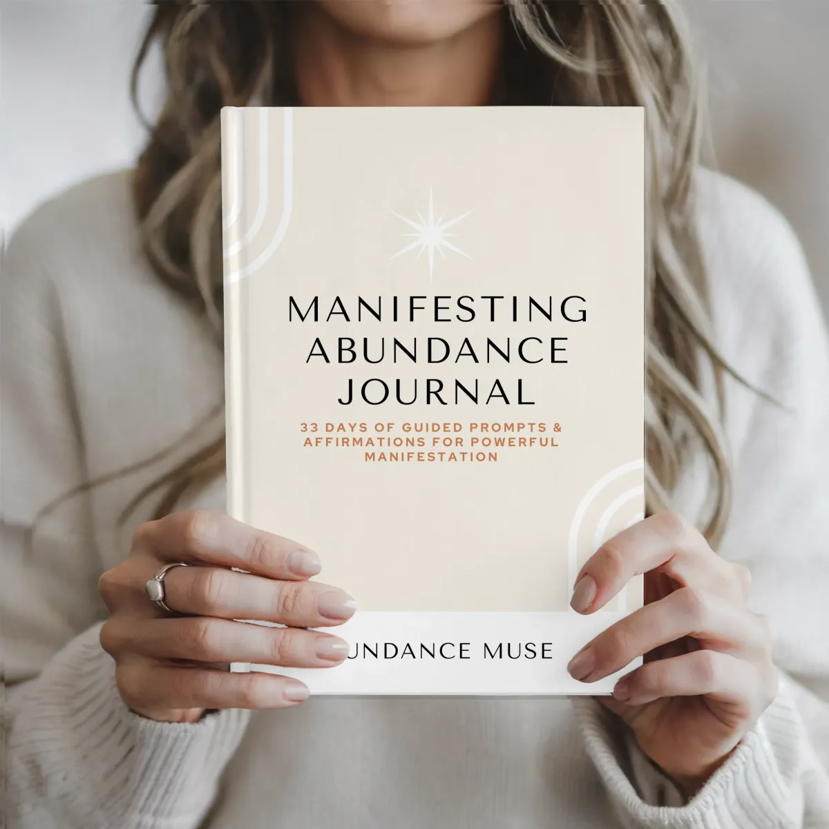 Stephanie Dianne holding the Manifesting Abundance Journal—designed to bridge mindset and strategy with grounded manifestation rituals.