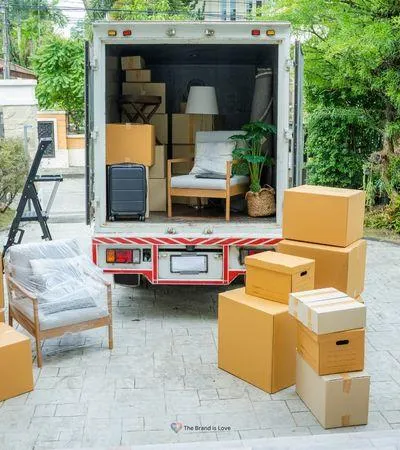 A moving van with stacked boxes in front, representing affordable senior relocation assistance for smooth transitions.