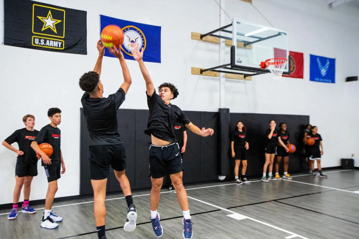 Youth Basketball Training Image One boy shoots basketball one boy defends