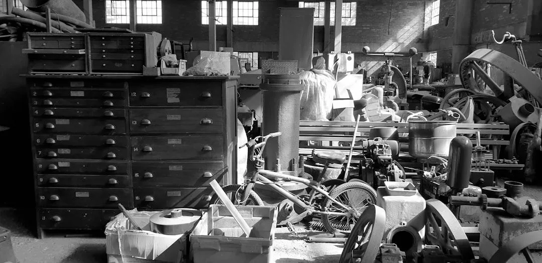 A pile of junk inside of a garage waiting to be hauled away.