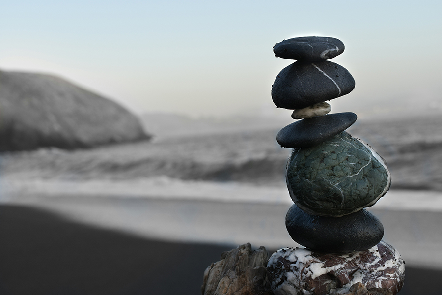 Rocks balancing on beach at ocean.
