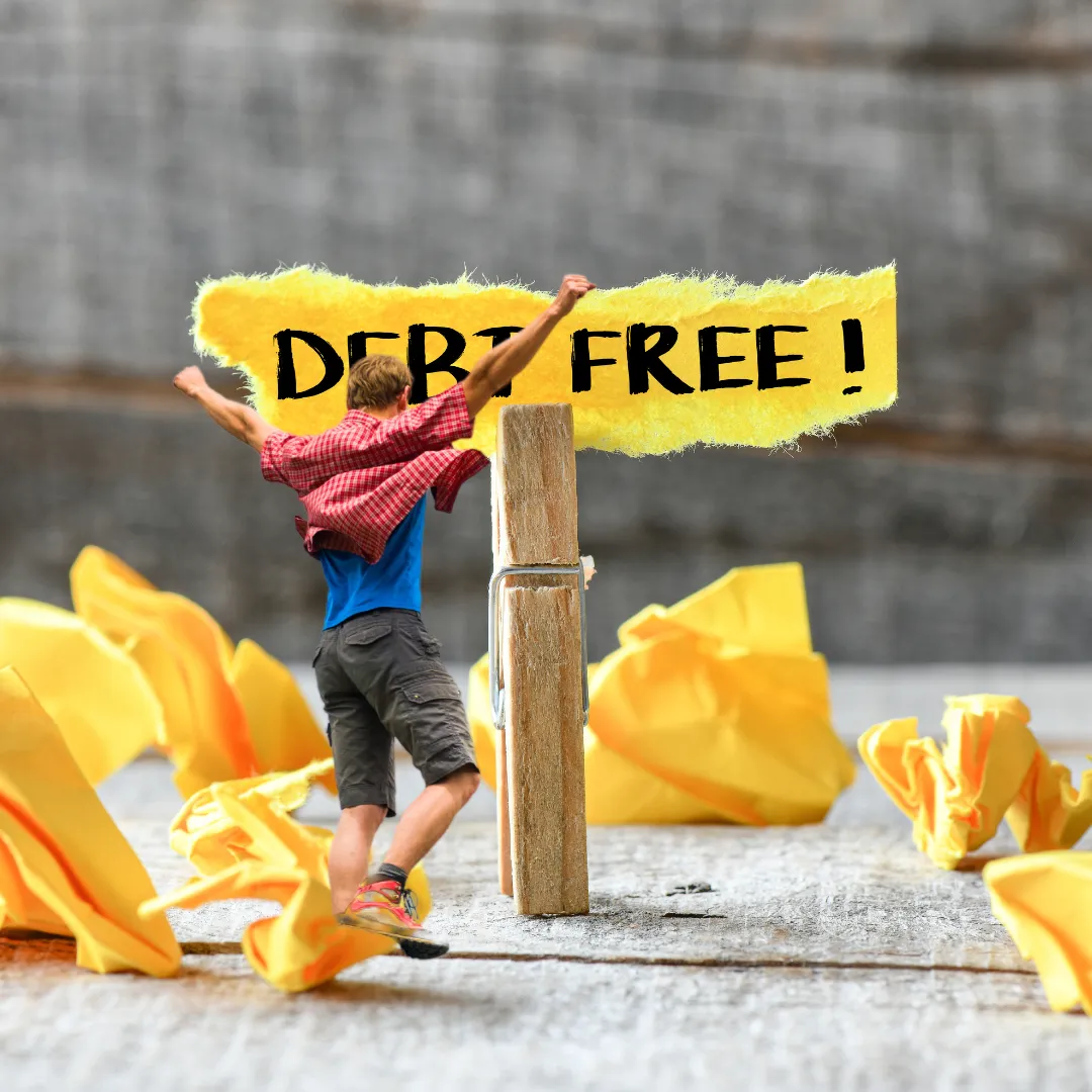 Person celebrating in front of a 'Debt Free' sign, symbolizing the transition to wealth building.
