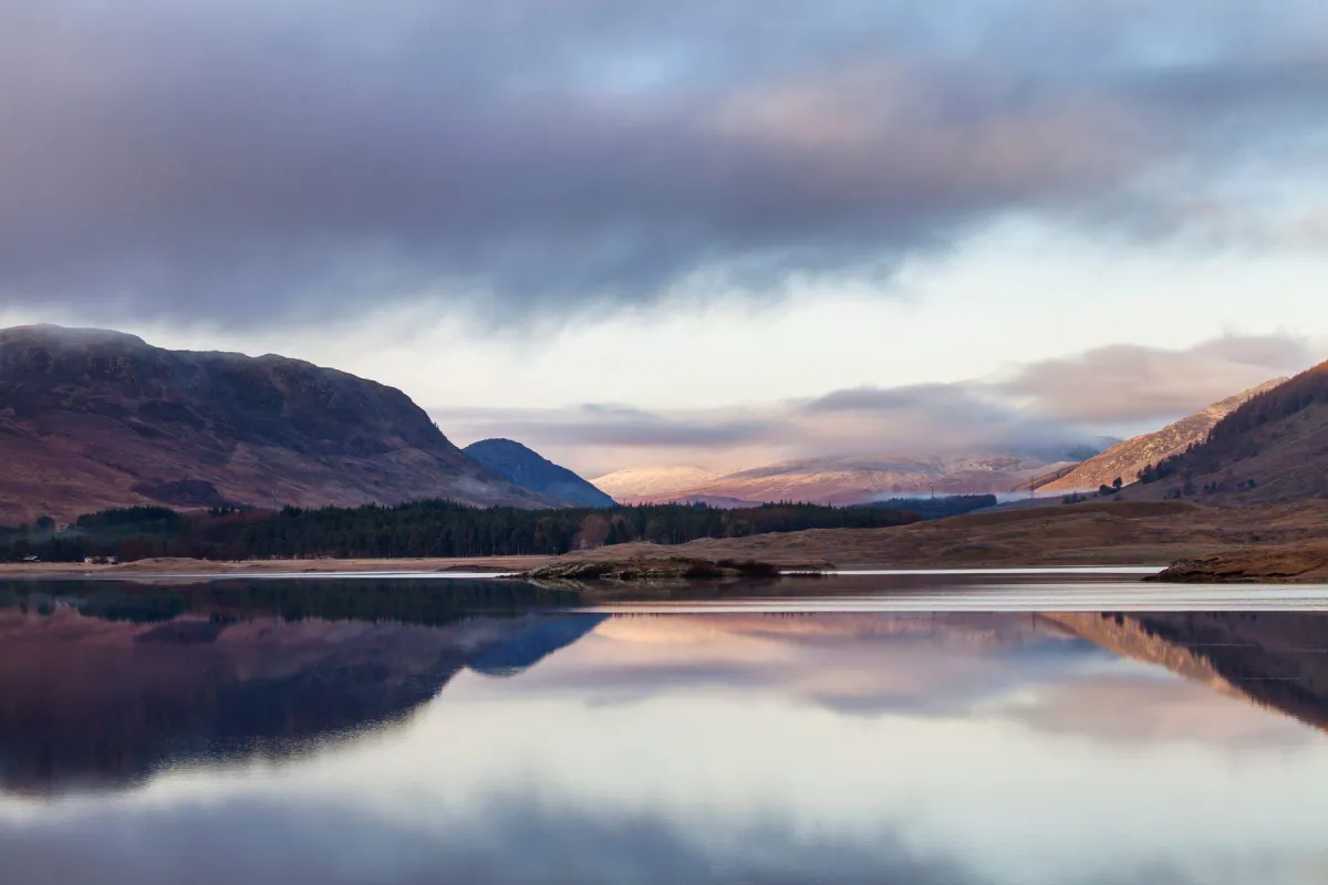 A loch in the Speyside region of the Scottish Highlands at dusk, the landscape that shapes the region's whisky.