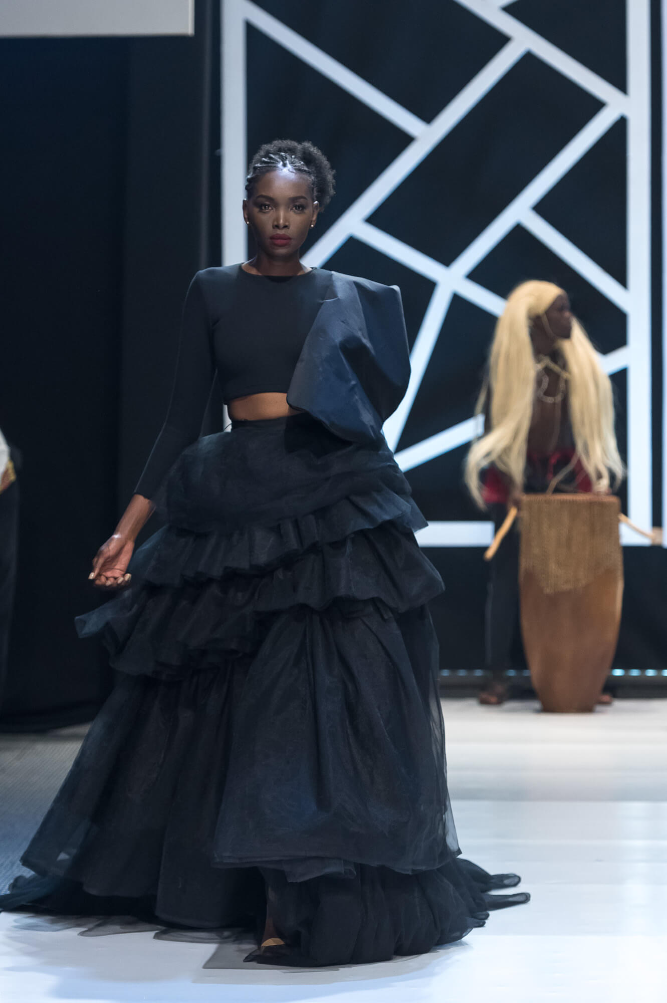 Woman in hat smoking a cigarette outdoors.