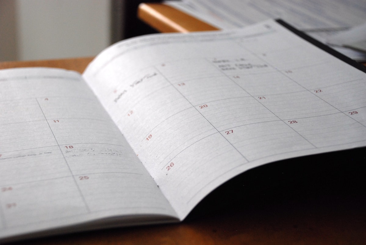 An open monthly planner on a wooden desk, ready to pencil in a training restart