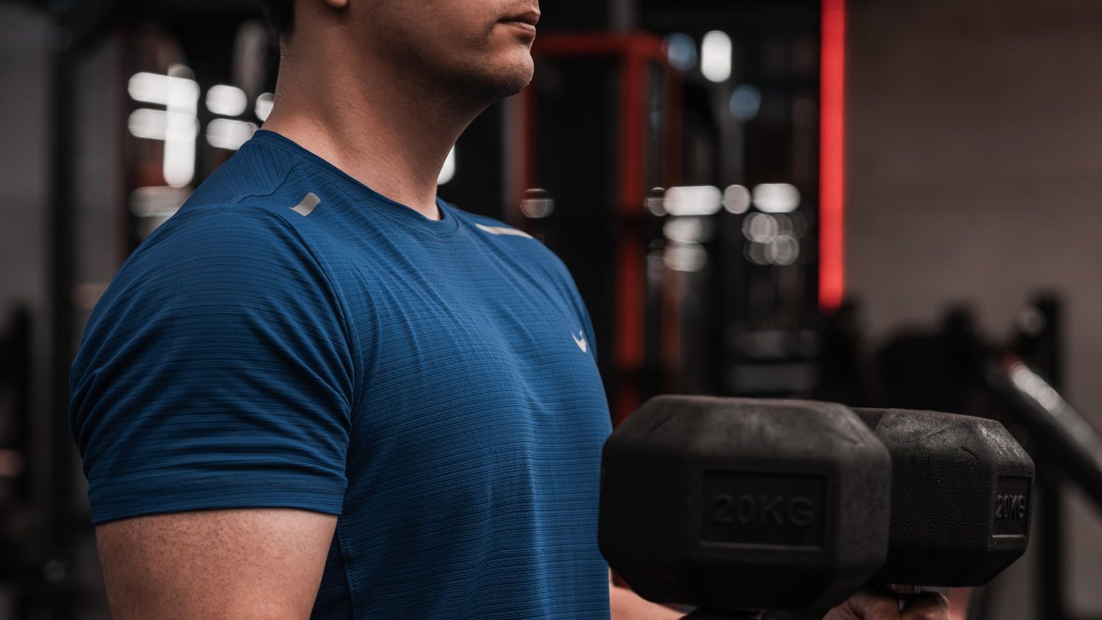 Man training with dumbbells in a gym during a short strength session