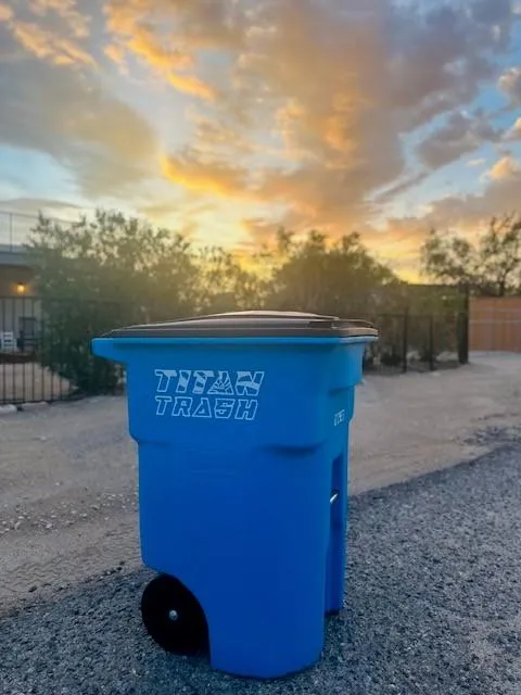 Stack of blue Titan Recycle & Trash bins with company logo printed on the side.