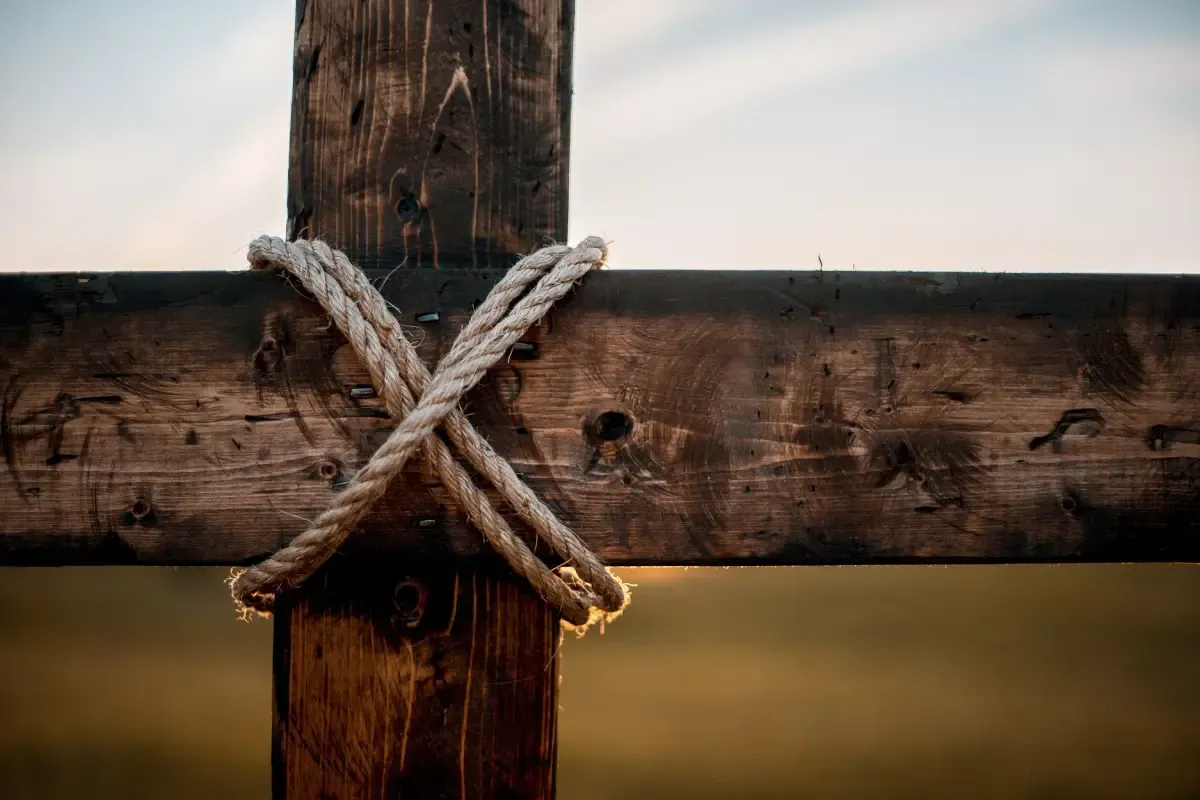 Close-up of a wooden cross with rope wrapped around the beams.
