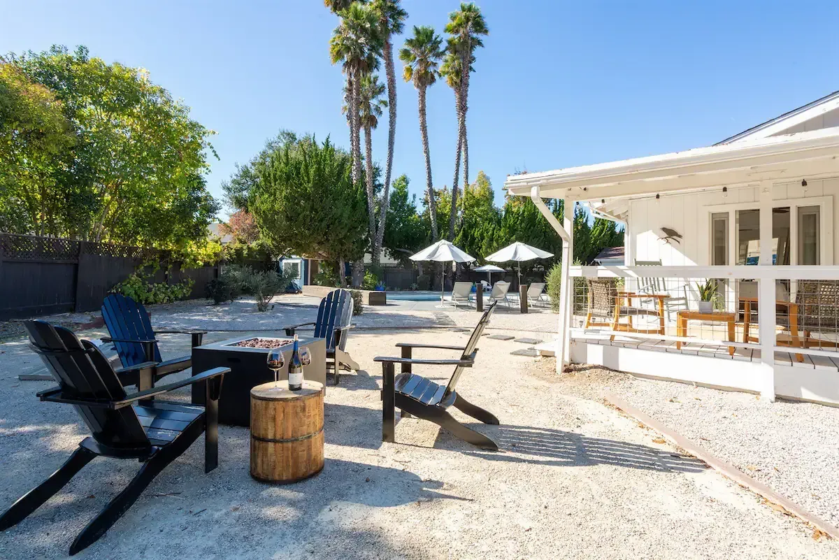 At Seven Palms, the backyard has cozy spots for 10 people, a warm pool with safety cover, and privacy from tall trees and fencing. Guests can cook outside, chill by the firepit, and play games like bocce ball. There's also fast internet, a room for work or yoga, and free bikes with wine coolers for town rides.