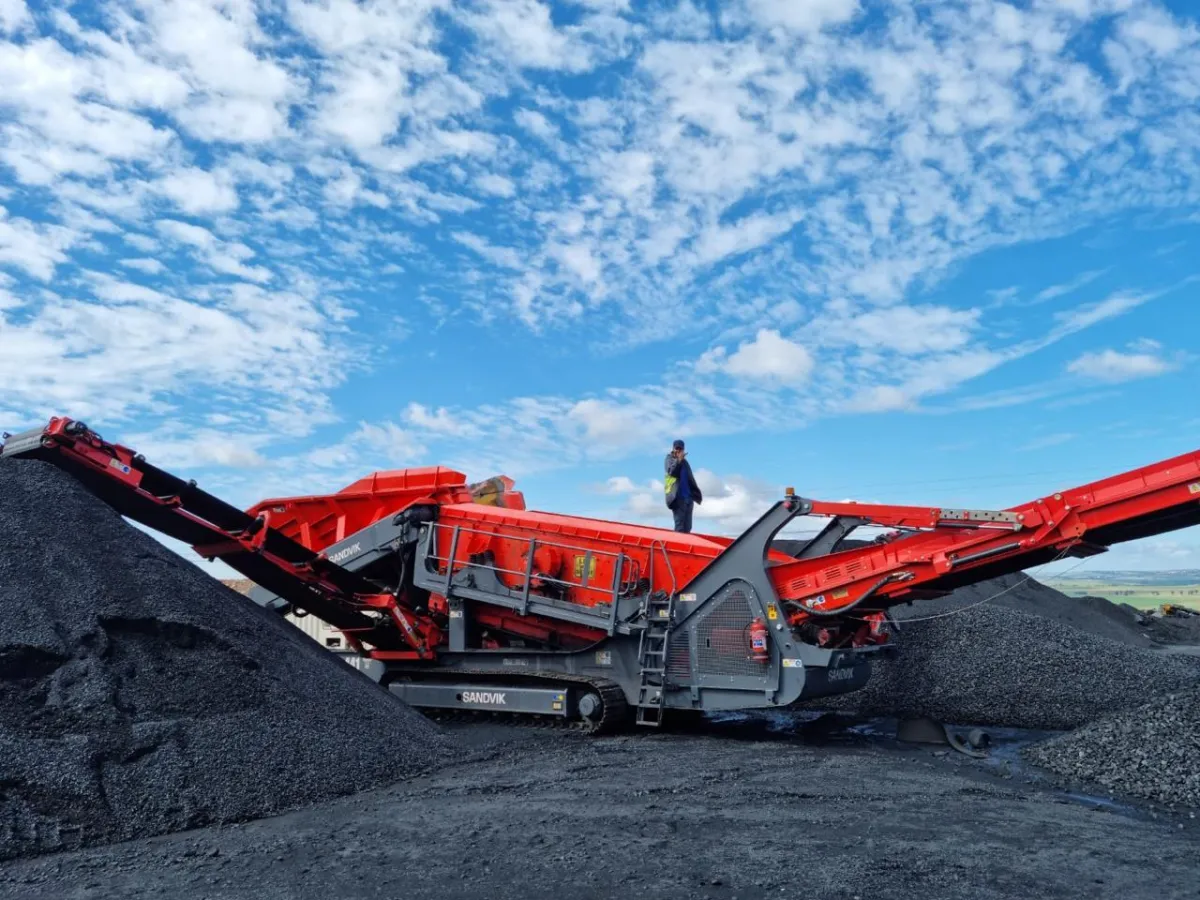 a train traveling past a pile of coal