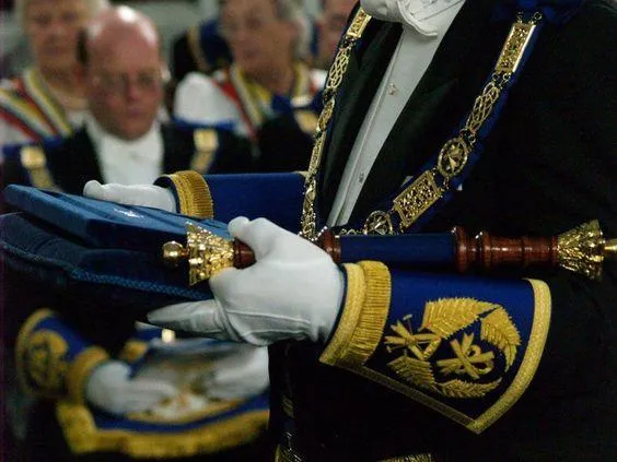 "Masonic members in ceremonial attire participating in a traditional Freemasonry event."