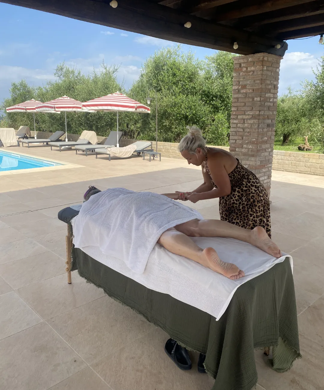 image of massage on a client by the pool side