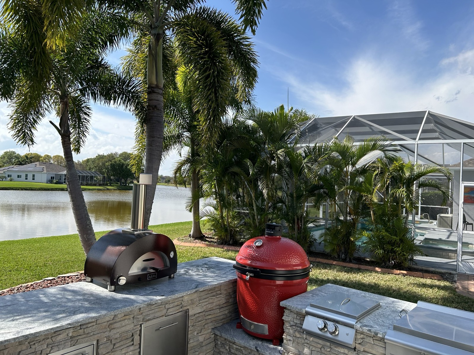 Canalside outdoor kitchen with bar seating and red stools, Brevard County FL