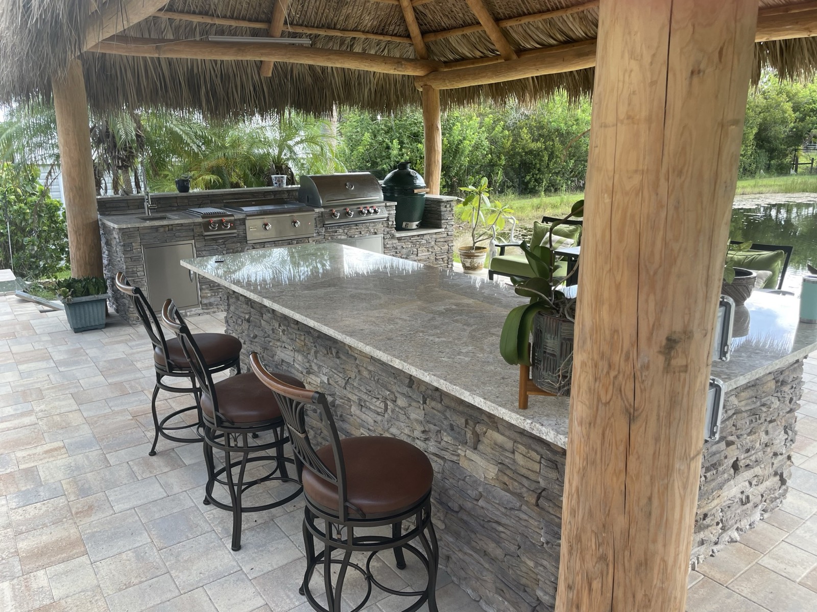 Custom outdoor kitchen with bar seating under a pergola in Brevard County, FL