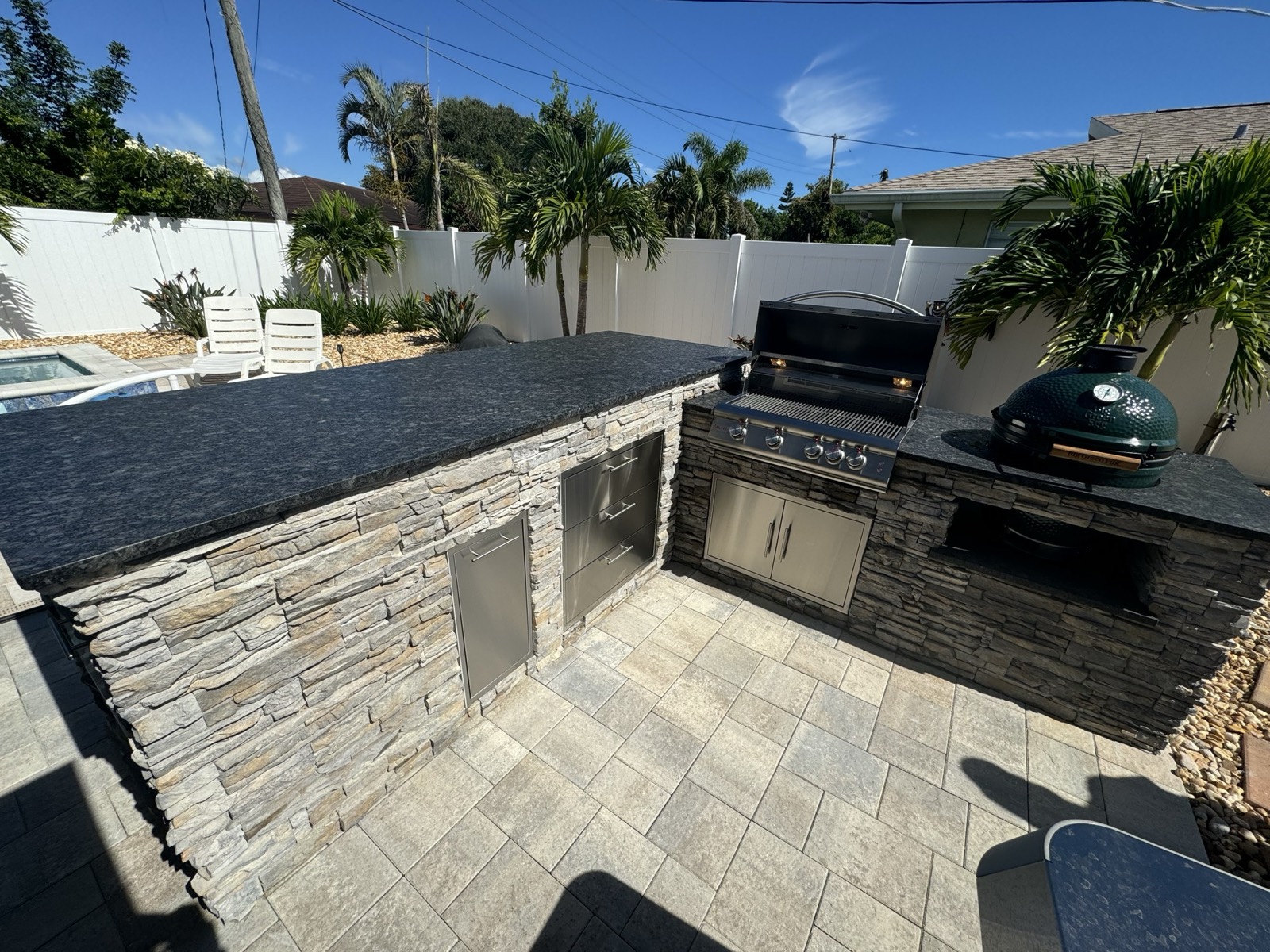 Custom outdoor kitchen with dark granite countertops overlooking a canal in Brevard County, FL