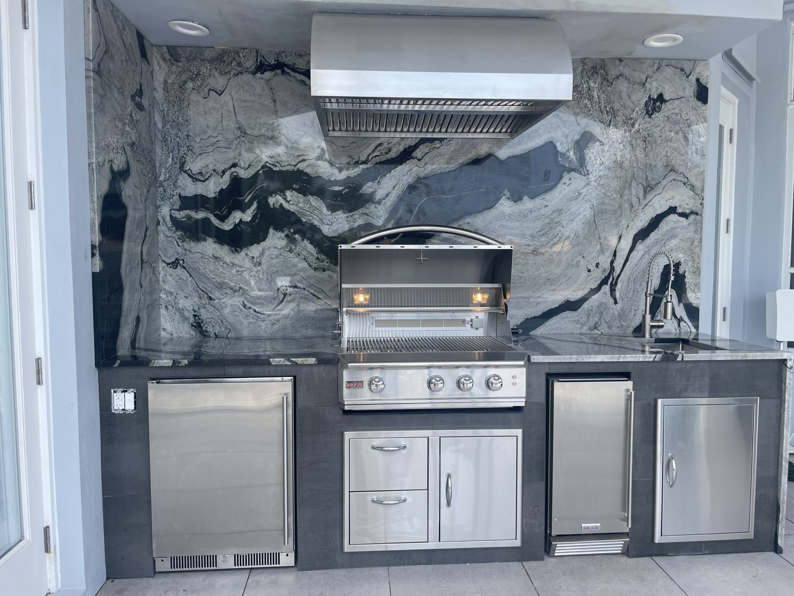 Premium granite waterfall-edge countertop on a custom outdoor kitchen
