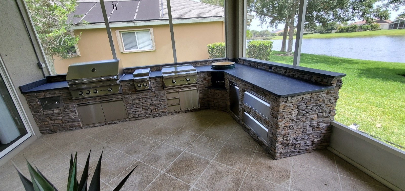 Screened-in outdoor kitchen with dark granite countertops, Florida