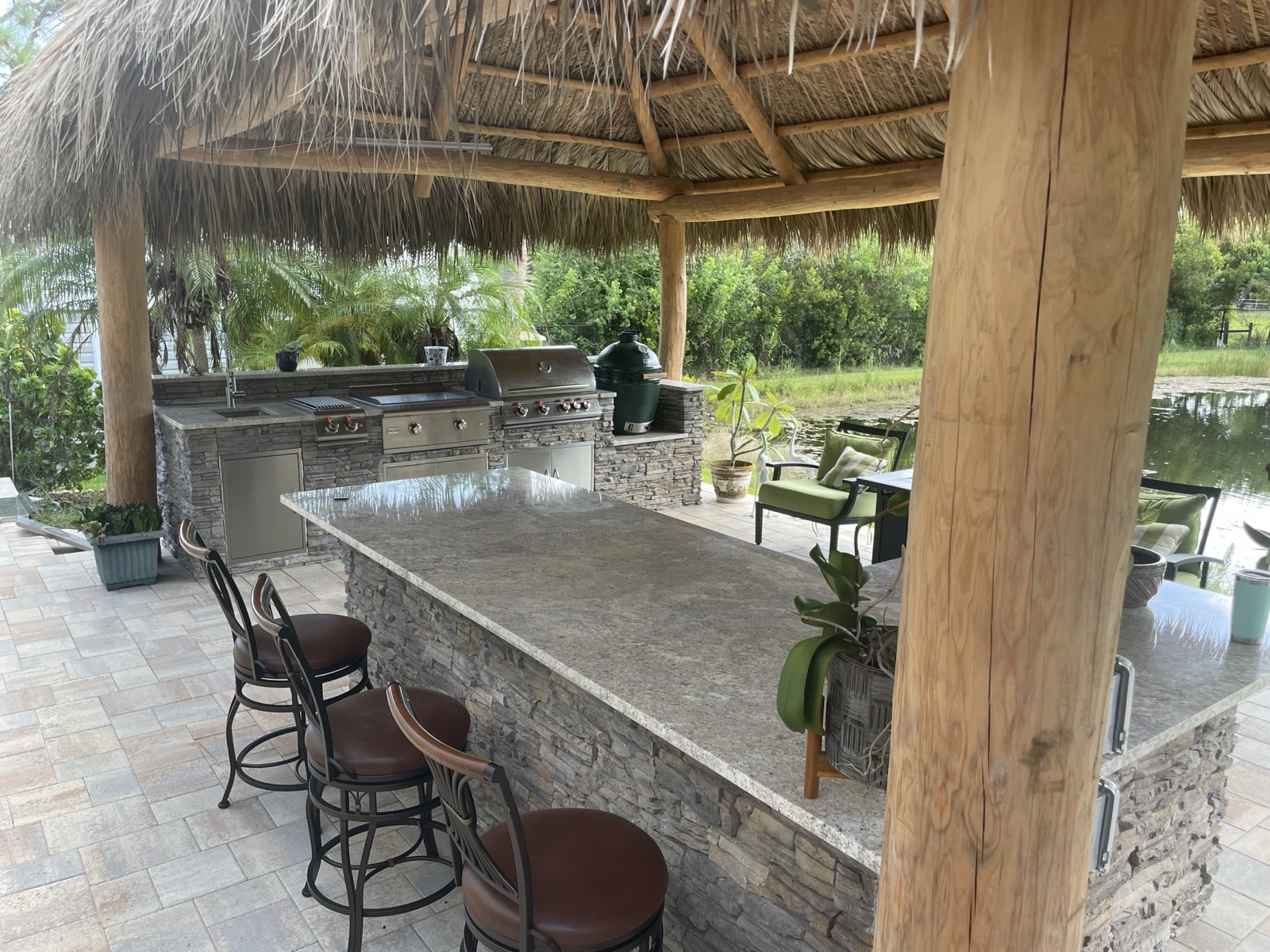 Wood pergola with bar seating over a custom outdoor kitchen