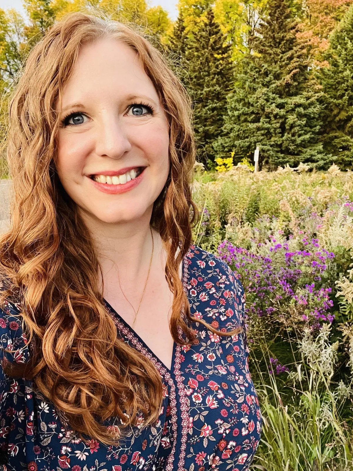 Author Farrah Jane standing in a field of wilflowers