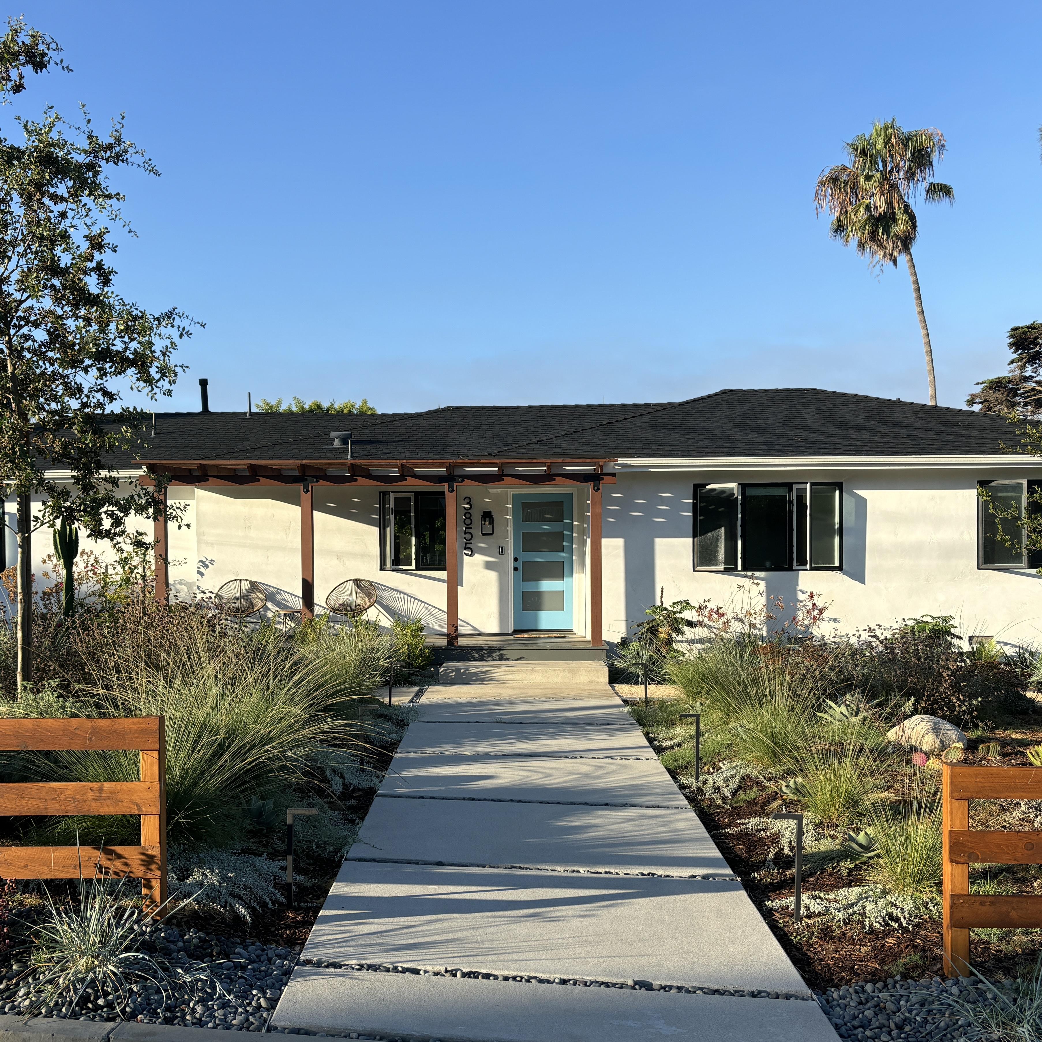 Straight concrete walkway flanked by native grasses.