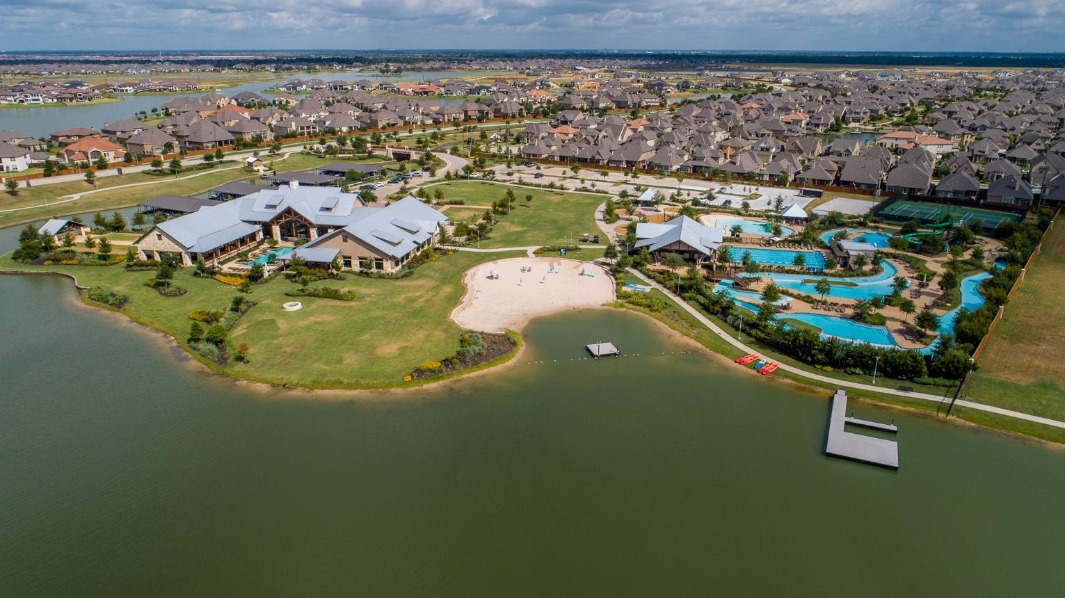 Cypress, Texas master-planned community featuring a neighborhood lake, walking and biking trails, landscaped park space, and nearby residential homes.