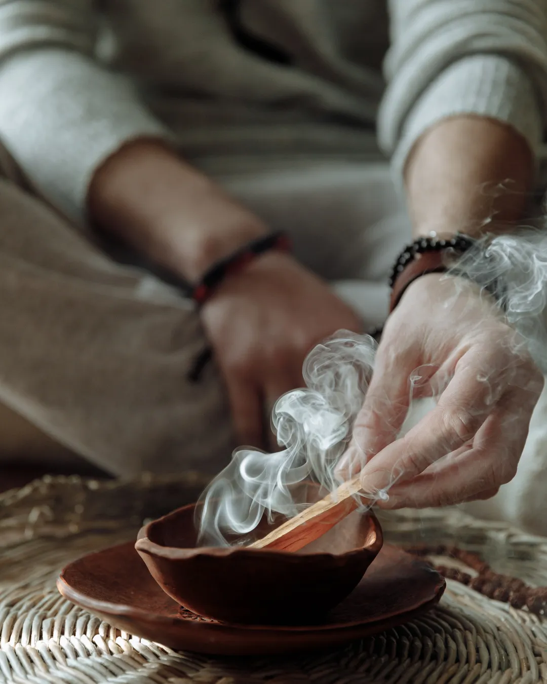 A serene woman quietly journaling in a warm, sunlight-filled space surrounded by gentle earth tones