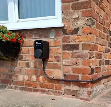 Domestic EV charging point mounted on an exterior brick wall, illustrating Electro Virium Ltd's home charger installation services