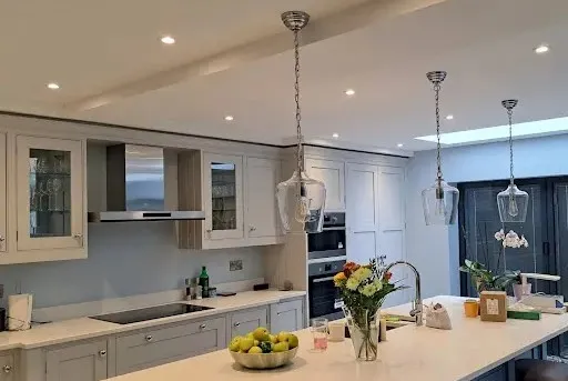 Modern kitchen featuring pendant lights above the island and recessed LED ceiling spotlights, illustrating Electro Virium Ltd's lighting services