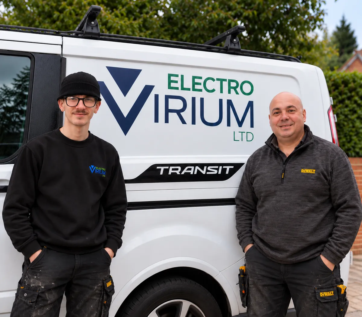 Gary and Max from Electro Virium Ltd standing beside their branded electrical services van in Macclesfield