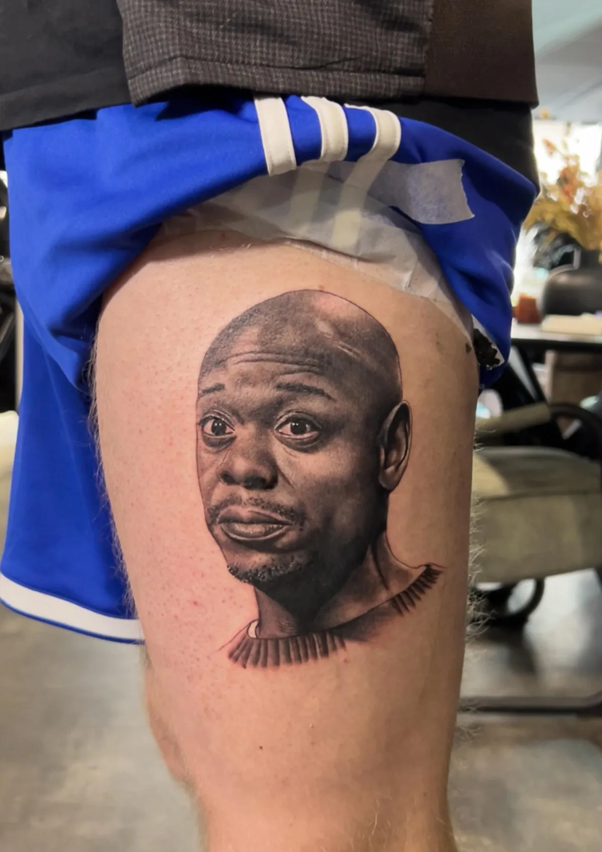 person in blue denim shorts and white nike sneakers standing on gray concrete floor