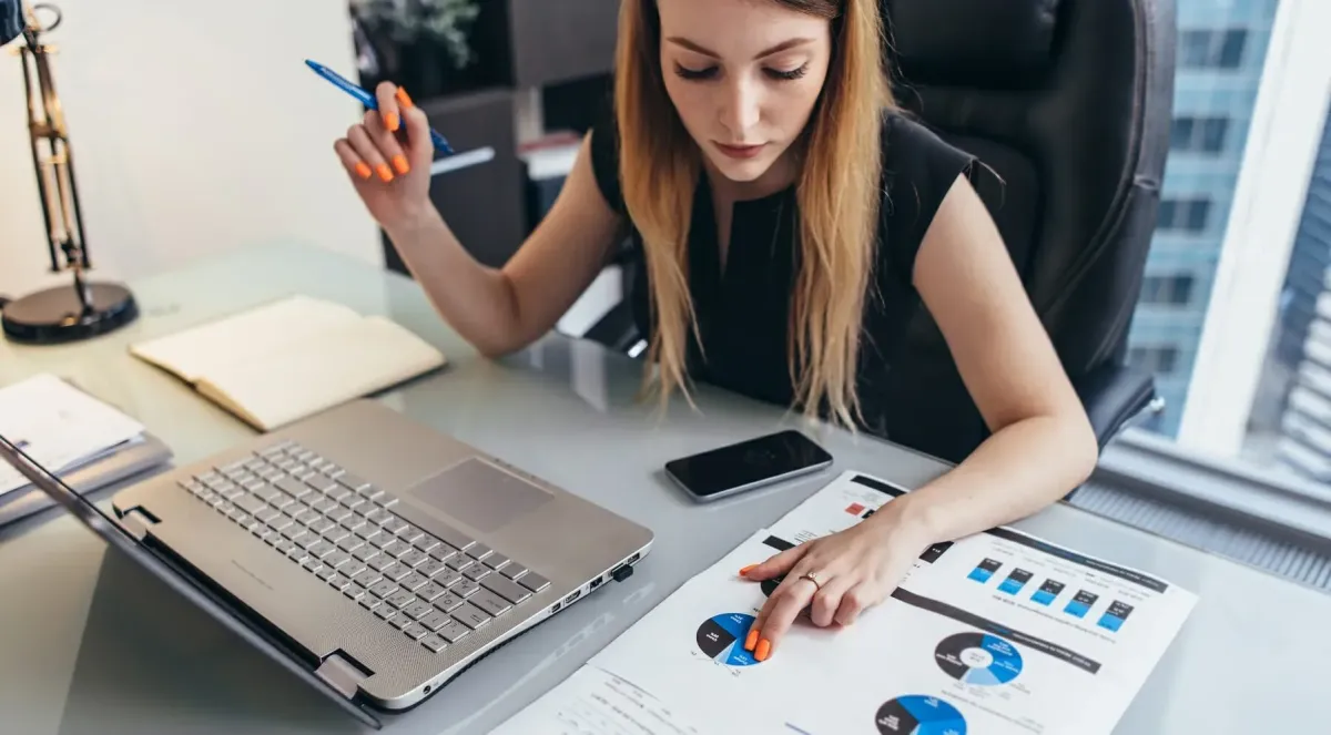 Elderly couple reviews finances at home on couch.