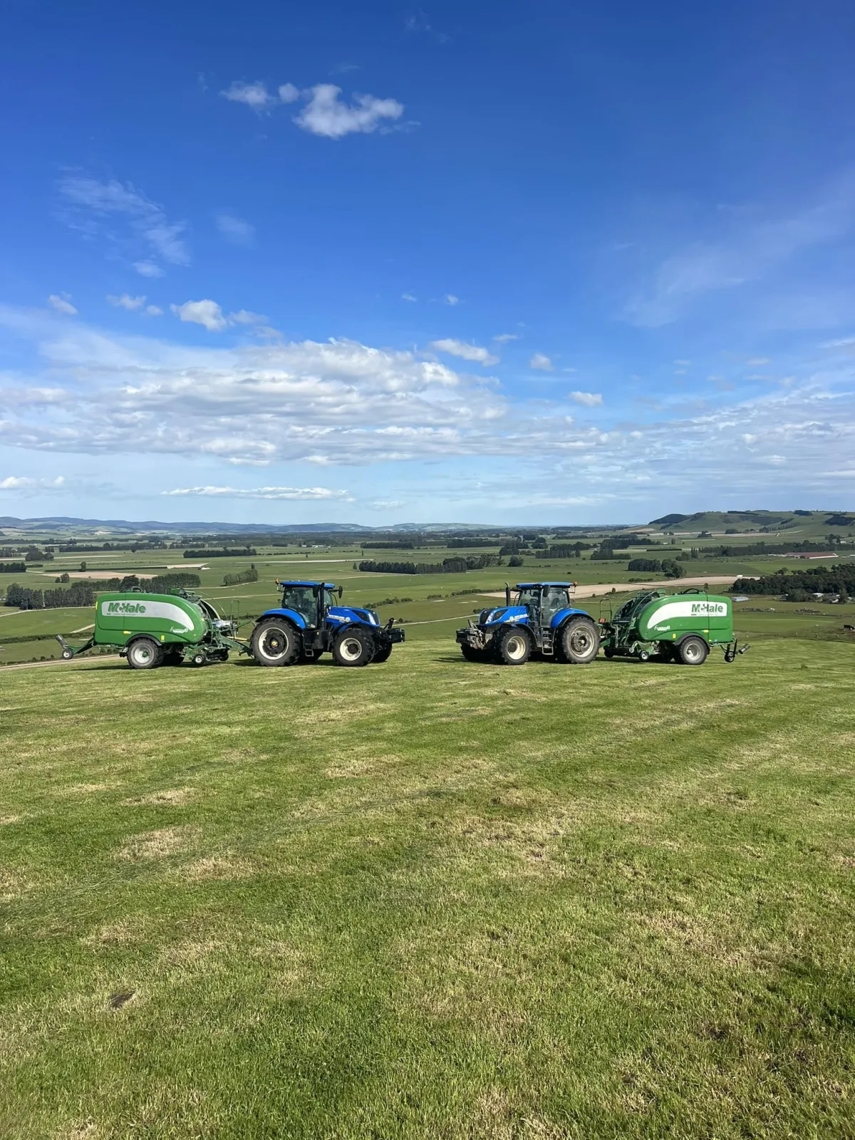 Tractors lined up in a Southland paddock with baleage wrappers ready for silage production