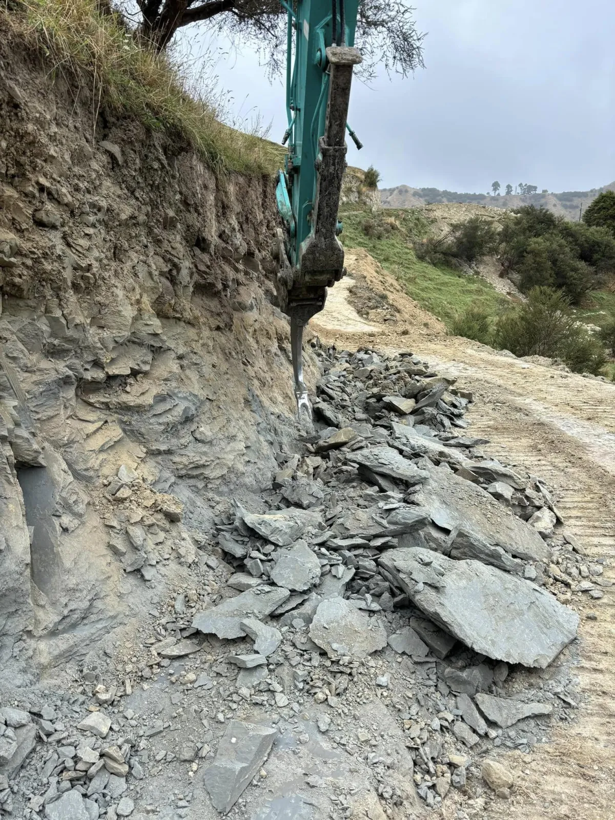 Excavator digging and clearing land for a construction or landscaping project.