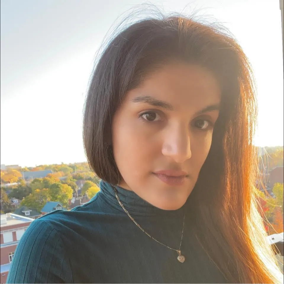 Mexican-Canadian woman with longer dark hair looking at camera