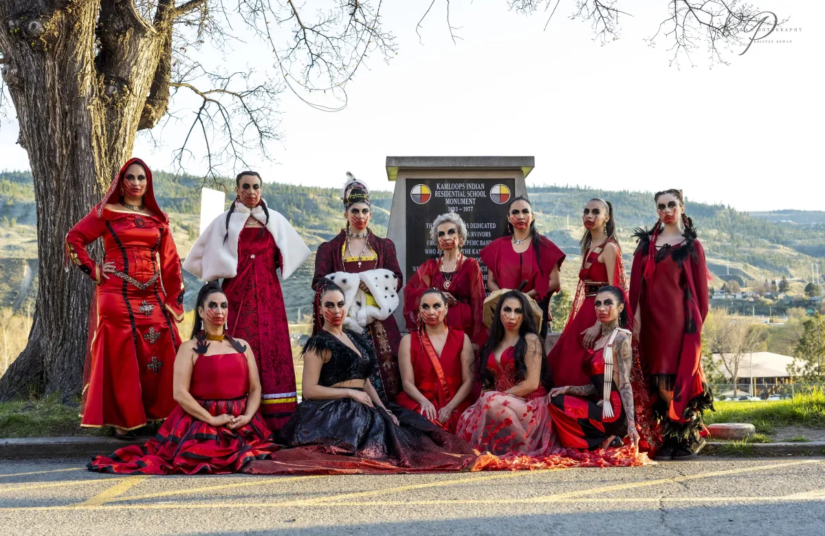 Image of several  Fashion Speaks International Indigenous models dressed in various red dresses. Photographer Kristen Rowan, Hair by Annie Peters, Makeup by Ruth Desjarlais and Echo Desjarlais.