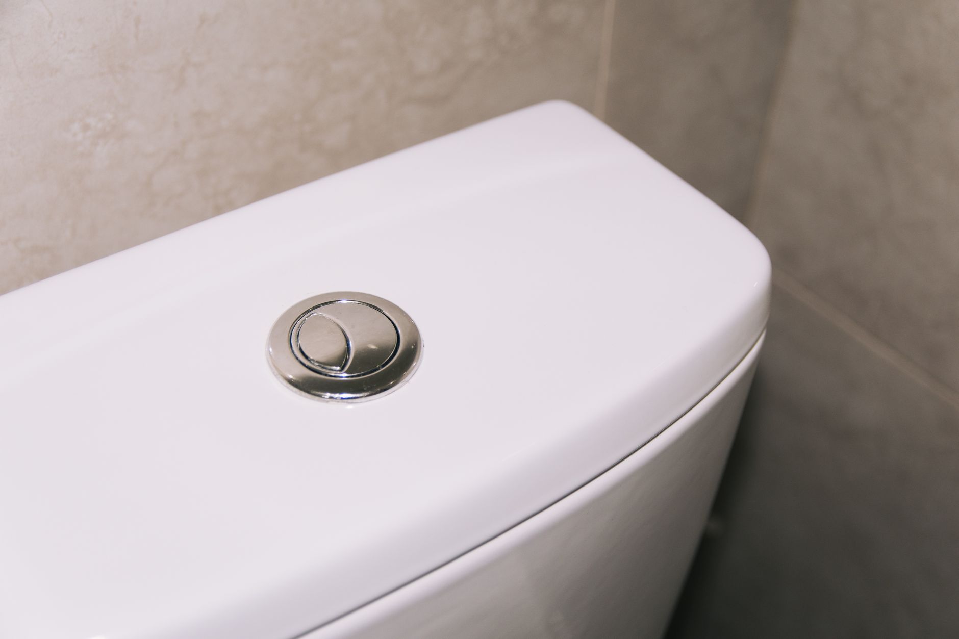 Plumber replacing a worn flapper inside a toilet tank