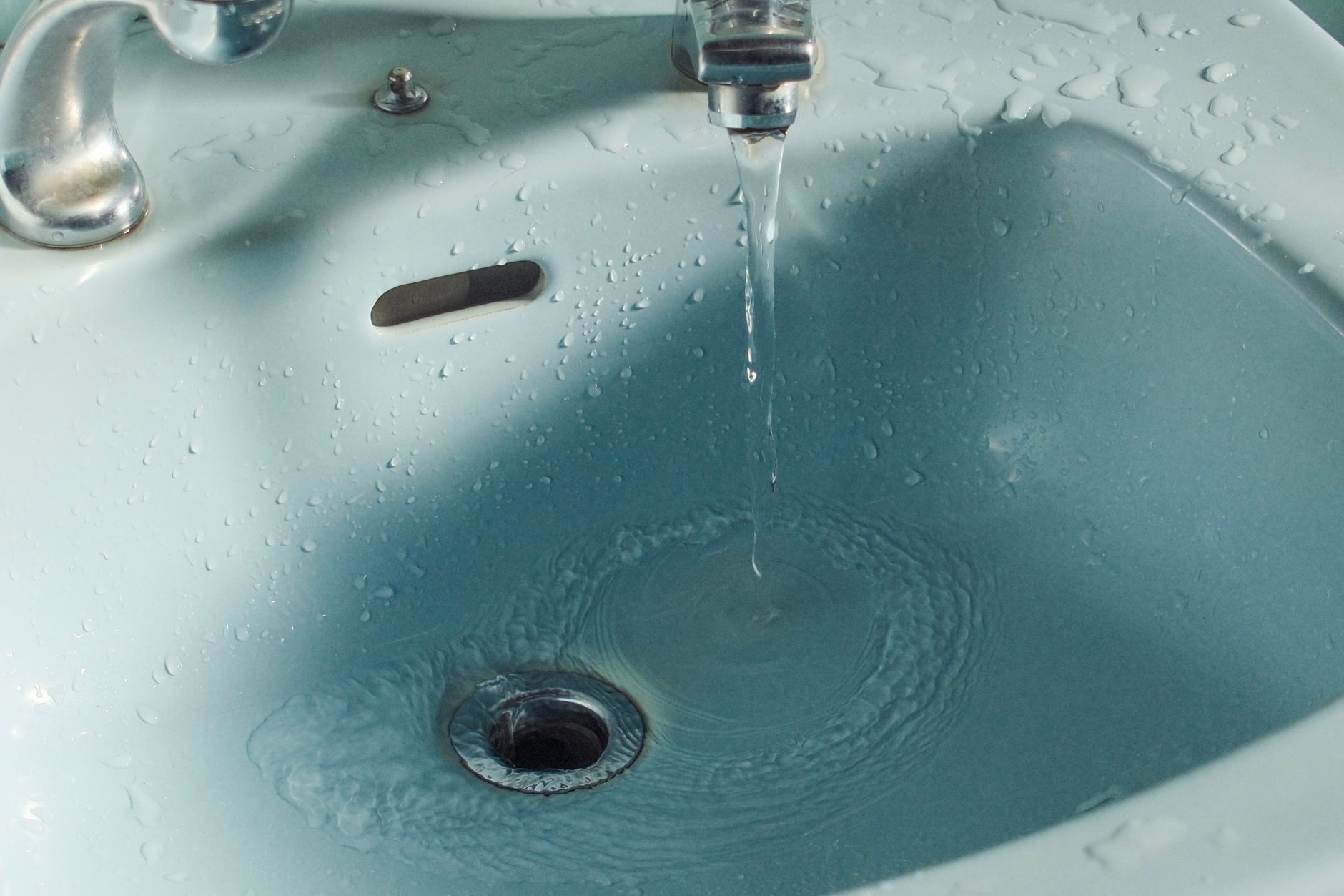 Slow-draining bathroom sink full of standing water