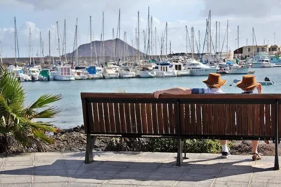 A mature couple looking thoughtfully at a tablet, evaluating their retirement readiness and financial plan
