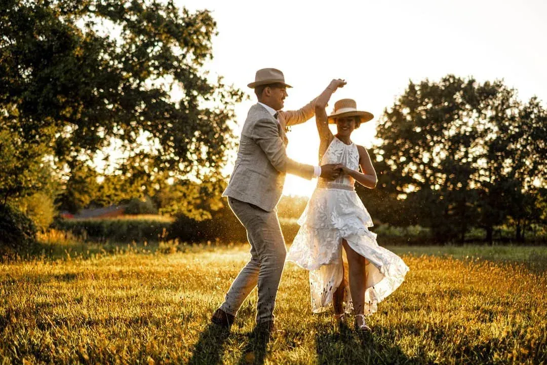 People are dancing under a disco ball and lights.
