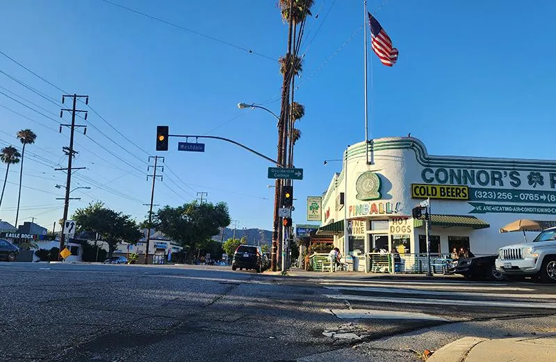 A view of the street in Eagle Rock, California, showing a corner building with a US flag