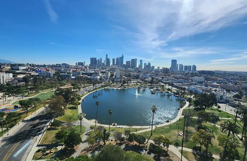  An aerial view of a park with a lake, overlooking downtown Los Angeles