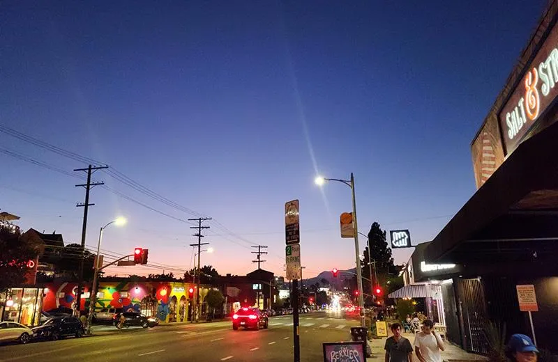 A wide-angle view of a street in Silver Lake at dusk, with streetlights and cars