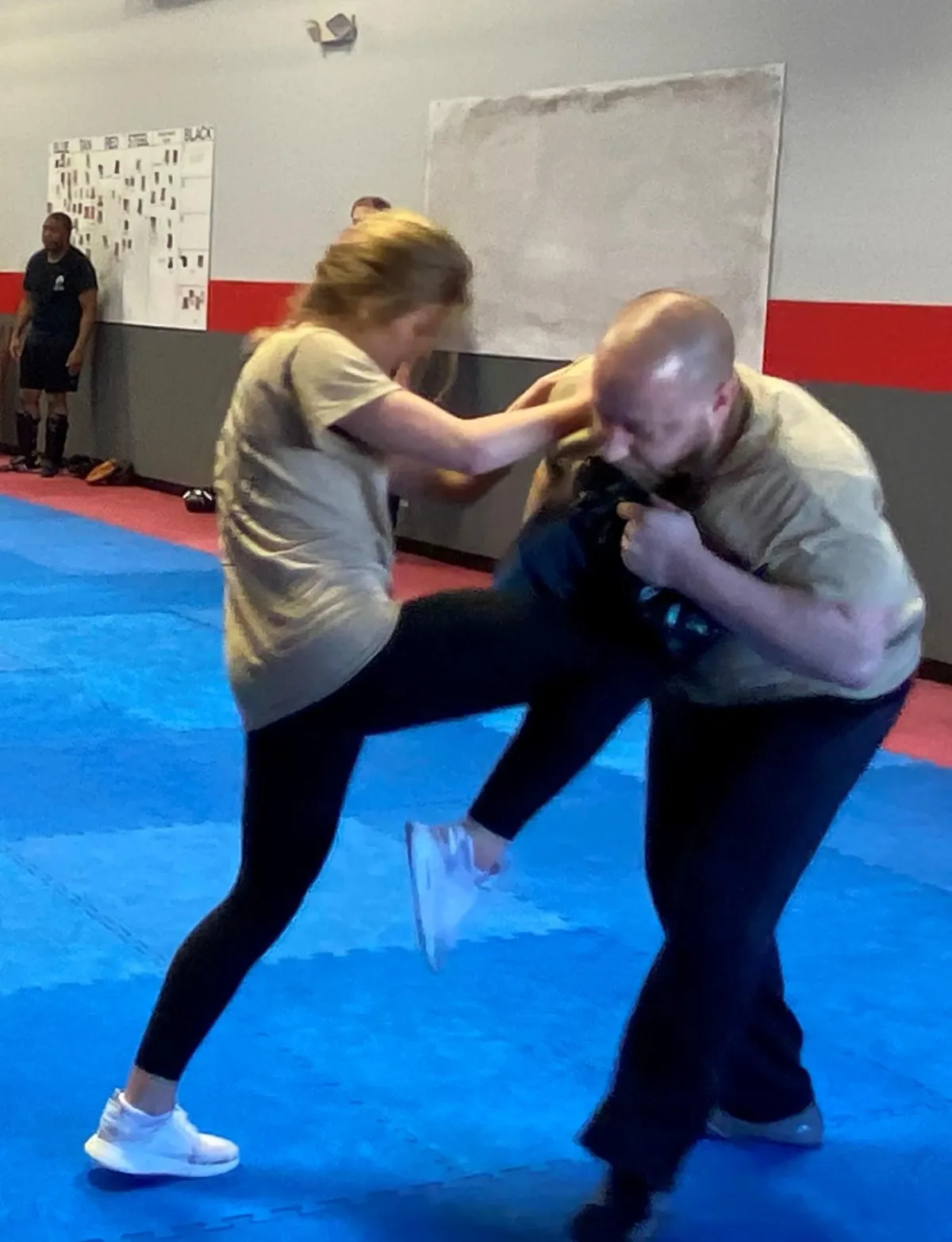 Teen girl practicing Krav Maga knee strikes into a pad during self-defense training at Krav Maga LKN in Cornelius, NC