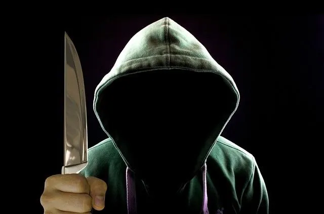 Faceless thug with knife used to show difference between self-defense and martial arts