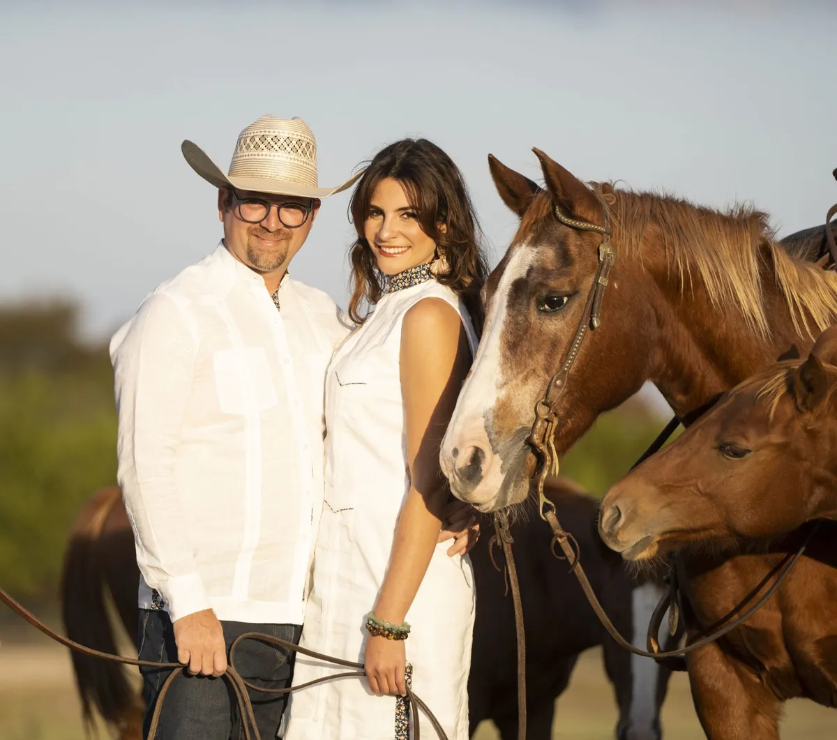 Jose and Astrid Sigala standing with horses