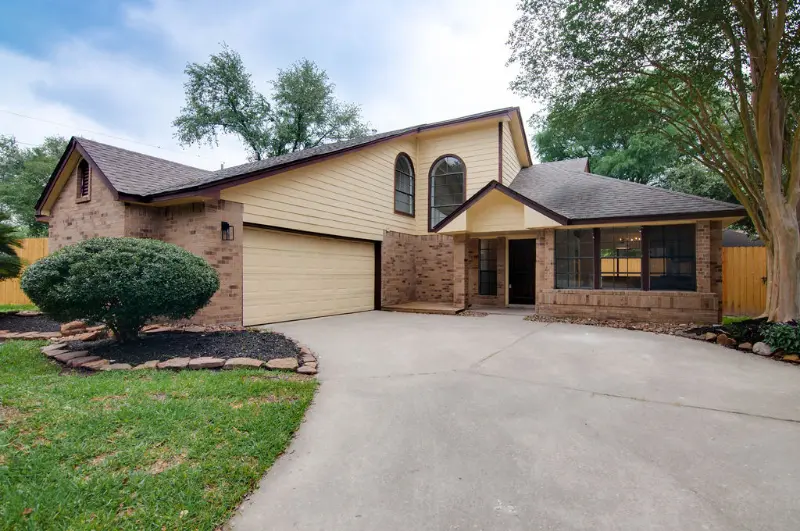 Two-story brick home with a two-car garage and curved driveway