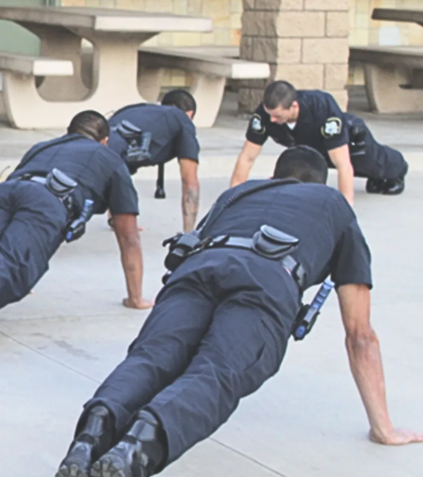 Group of police officers doing push-ups outside to represent Power Up For The Day Sponsor.