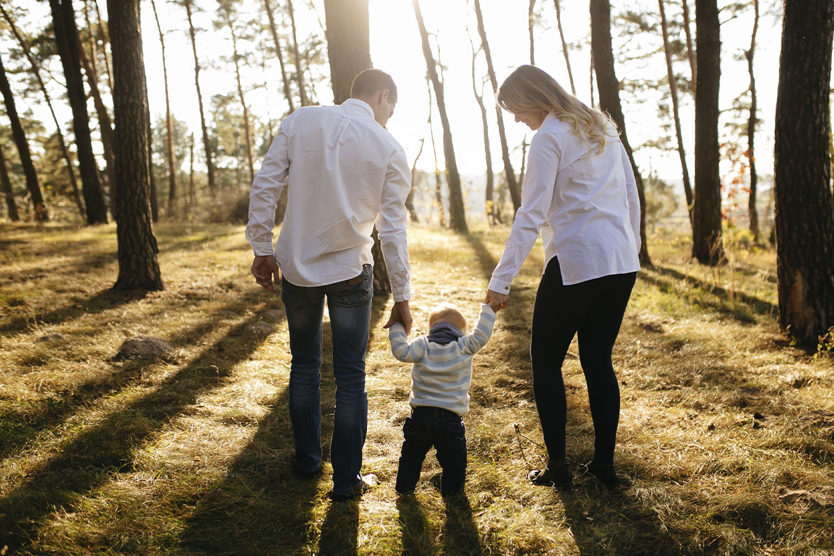 Familia hispana sonriendo en la sala, conversando sobre su futuro financiero y protección.