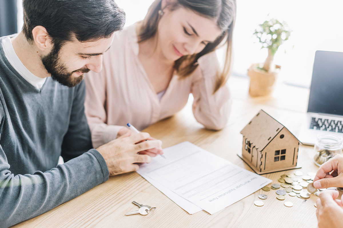 Familia hispana sonriendo en la sala, conversando sobre su futuro financiero y protección.