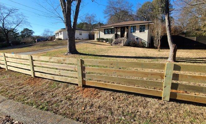 Newly installed wooden farm fence surrounding a home in Kalamazoo.